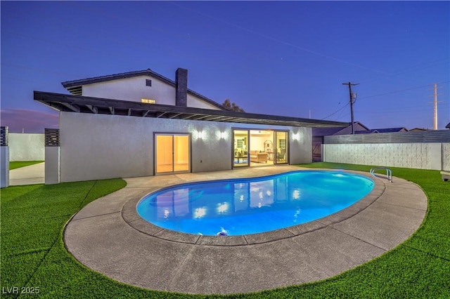 pool at dusk featuring a yard and a patio area