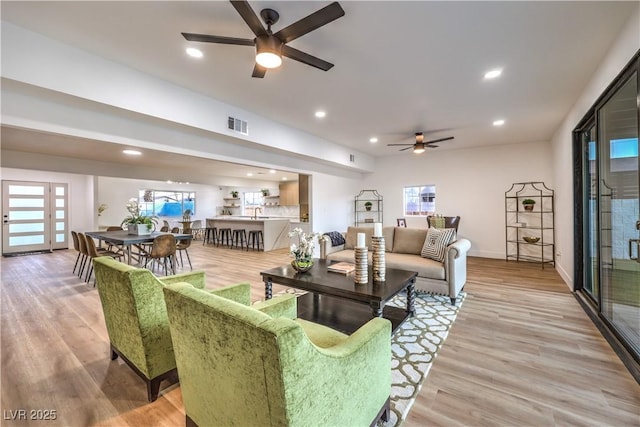 living room featuring ceiling fan and light wood-type flooring