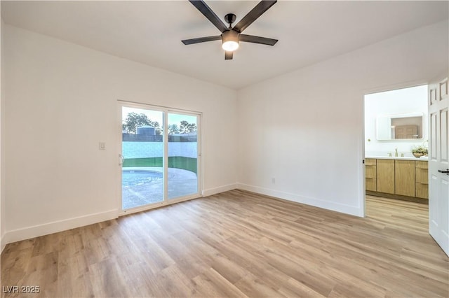 empty room with sink, ceiling fan, and light hardwood / wood-style floors