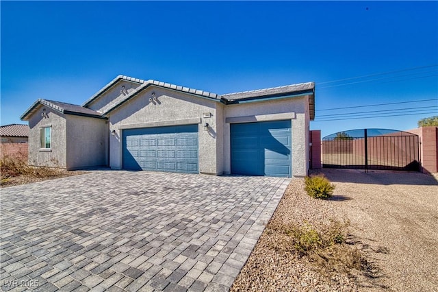 view of front of home featuring a garage, decorative driveway, and stucco siding