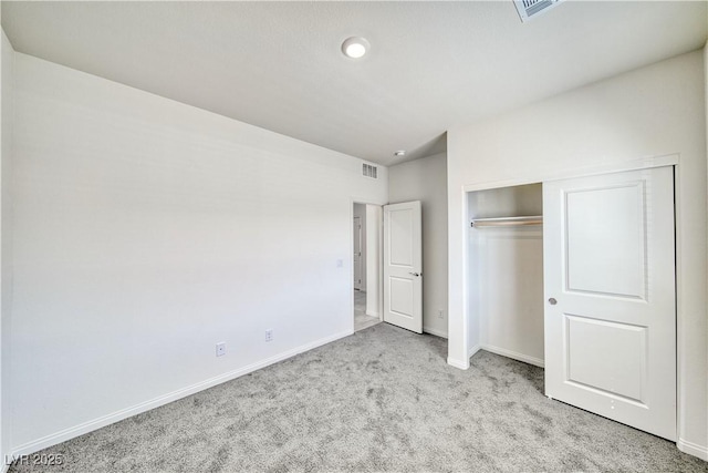 unfurnished bedroom with a closet, light carpet, visible vents, and baseboards