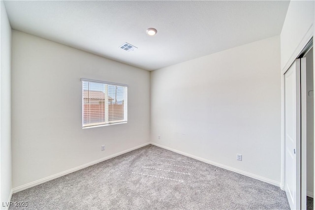 unfurnished bedroom featuring a closet, visible vents, light carpet, and baseboards