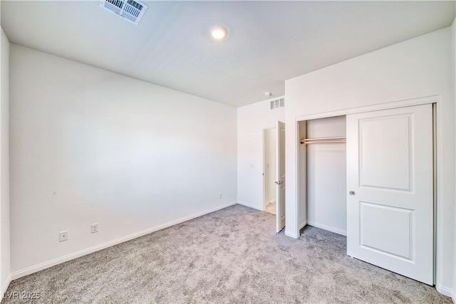 unfurnished bedroom with light carpet, a closet, visible vents, and baseboards