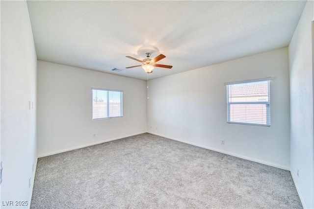 unfurnished room with light carpet, a textured ceiling, visible vents, and a ceiling fan