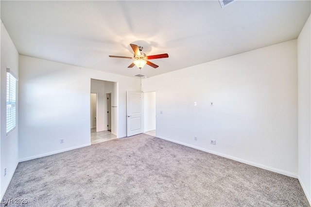 empty room with baseboards, a ceiling fan, and light colored carpet