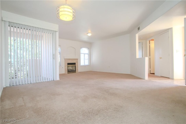 unfurnished living room featuring light colored carpet and a fireplace