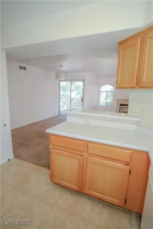 kitchen featuring light brown cabinetry, light carpet, and kitchen peninsula