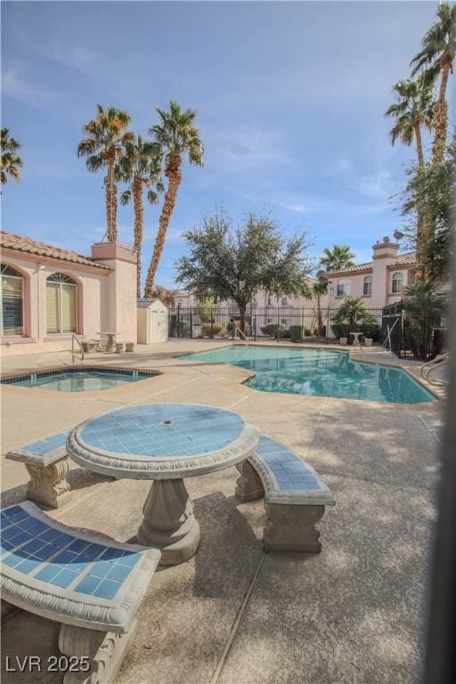 view of swimming pool featuring a patio area and a jacuzzi