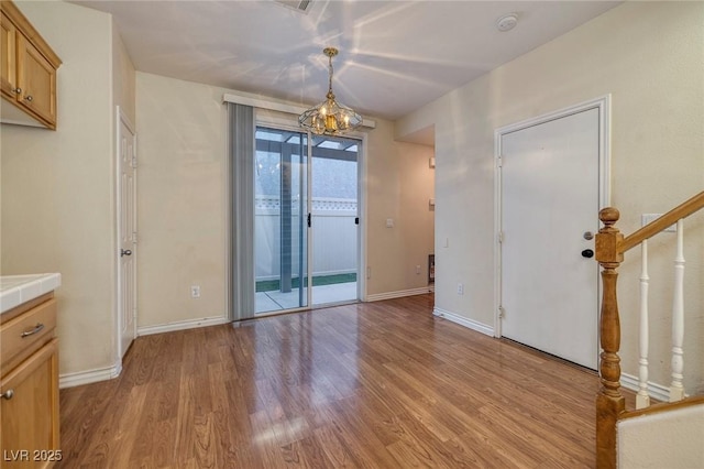 interior space with a notable chandelier and light wood-type flooring