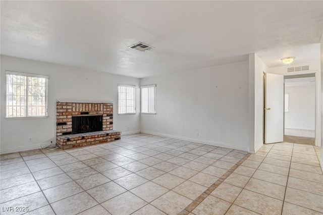 unfurnished living room featuring a brick fireplace and light tile patterned floors