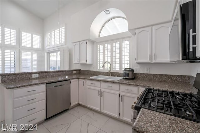 kitchen with stainless steel dishwasher, white cabinets, and range with gas stovetop