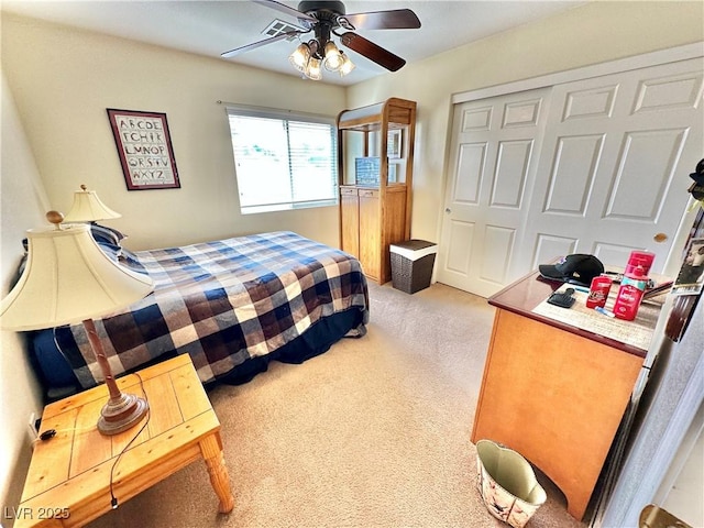 bedroom with a ceiling fan, a closet, and light carpet