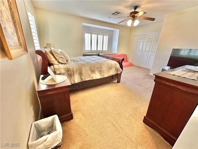 bedroom featuring a ceiling fan, a closet, visible vents, and carpet flooring