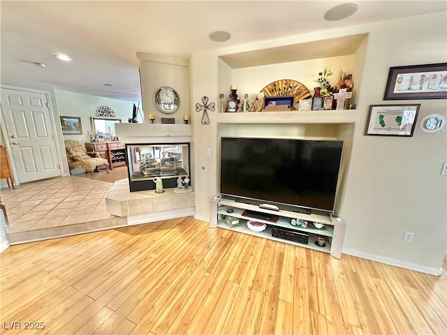 living area with baseboards and wood finished floors