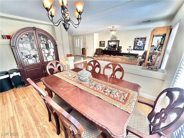 dining space featuring a chandelier, visible vents, and a healthy amount of sunlight