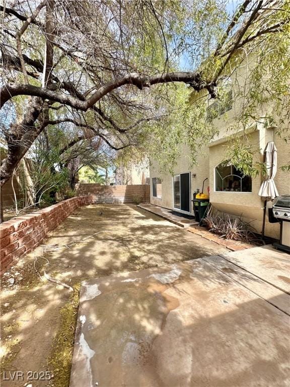 view of front of house featuring a patio area, fence, and stucco siding