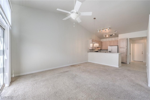 unfurnished living room featuring ceiling fan, high vaulted ceiling, light carpet, baseboards, and track lighting