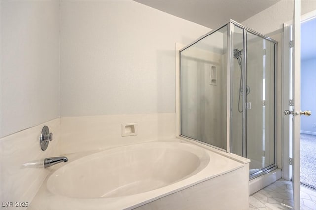 bathroom featuring a shower stall and a bath