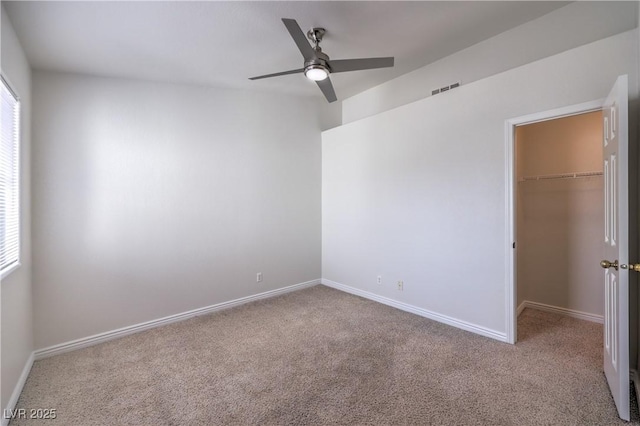 unfurnished room featuring plenty of natural light, carpet, visible vents, and baseboards