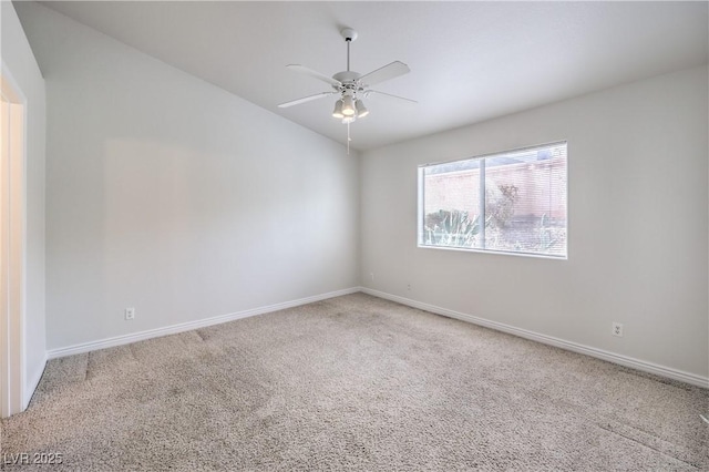 carpeted empty room featuring lofted ceiling, baseboards, and a ceiling fan