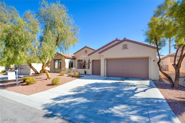 mediterranean / spanish-style house featuring concrete driveway, a tiled roof, an attached garage, and stucco siding