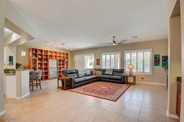 living room featuring light tile patterned floors, baseboards, visible vents, and a ceiling fan