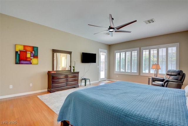 bedroom featuring light wood finished floors, baseboards, visible vents, and a ceiling fan