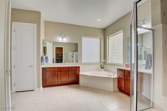 full bath with a stall shower, a garden tub, vanity, and tile patterned floors