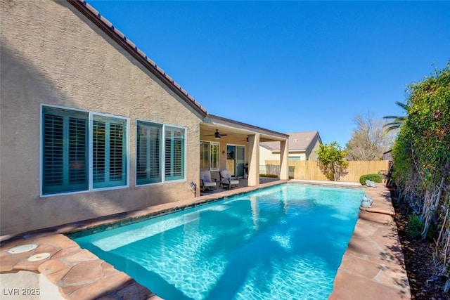 view of swimming pool featuring a fenced in pool, a fenced backyard, ceiling fan, and a patio