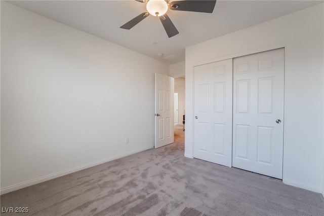 unfurnished bedroom with a closet, ceiling fan, and light colored carpet