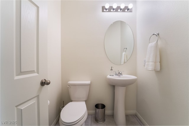 bathroom featuring sink, toilet, and tile patterned flooring