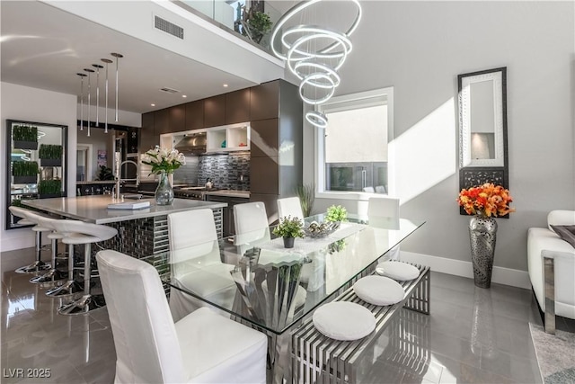 dining area with a notable chandelier, baseboards, and visible vents