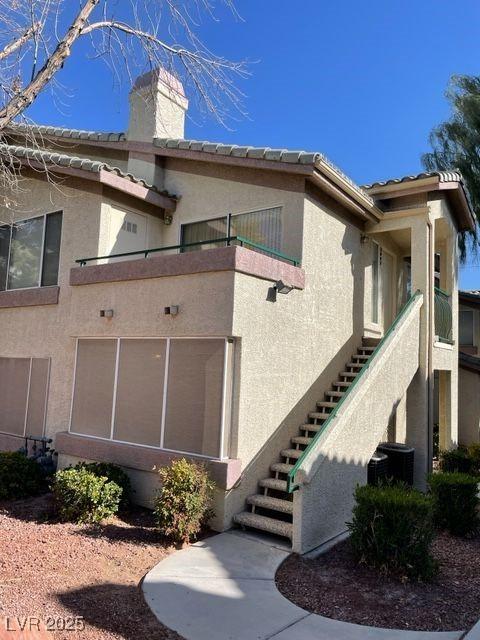 view of side of home featuring central AC and a balcony