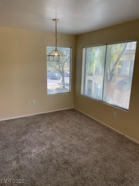 carpeted spare room with a textured ceiling