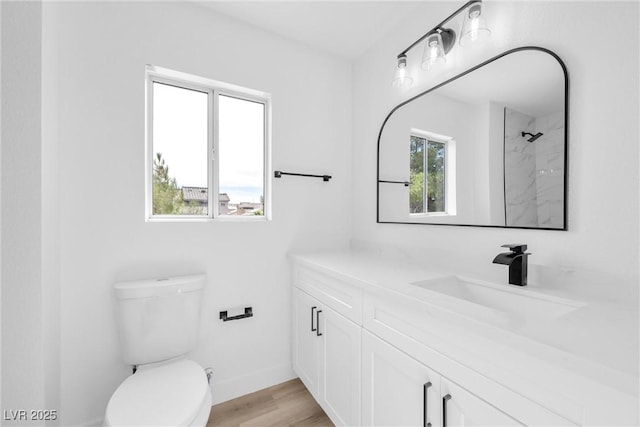 bathroom with hardwood / wood-style flooring, toilet, vanity, and a shower