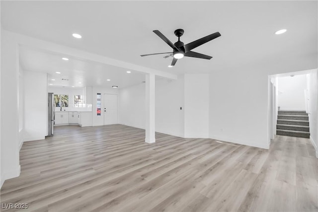 unfurnished living room with light hardwood / wood-style floors and ceiling fan