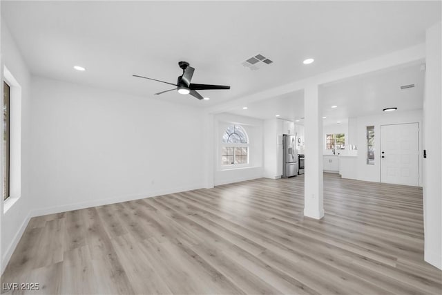 unfurnished living room with ceiling fan and light hardwood / wood-style floors