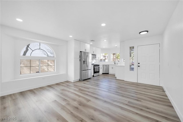 unfurnished living room featuring light hardwood / wood-style flooring and sink