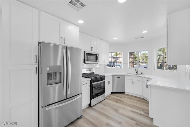 kitchen featuring white cabinets, light hardwood / wood-style floors, stainless steel appliances, and sink