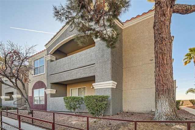 view of property exterior with stucco siding and a tiled roof