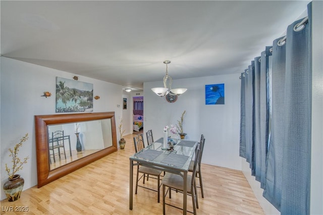 dining room featuring light hardwood / wood-style floors and a notable chandelier