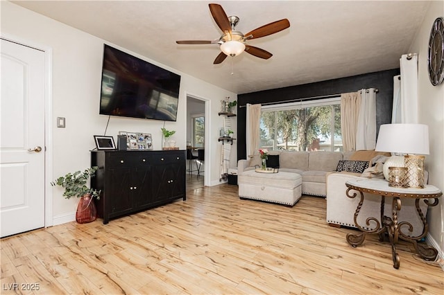 living room featuring ceiling fan and light hardwood / wood-style flooring