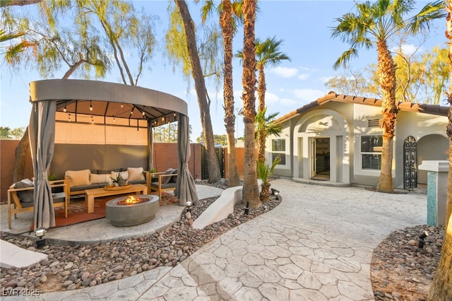 view of patio with an outdoor living space with a fire pit and a gazebo