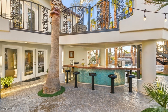 bar featuring decorative columns and french doors