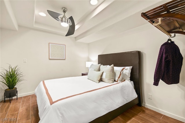 bedroom with ceiling fan and a raised ceiling