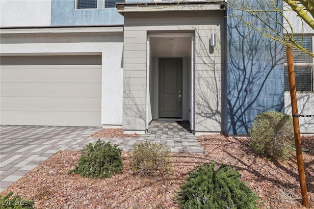 9690 Hiking Ave, Las Vegas, NV 89166 - view of exterior entry featuring an attached garage and stucco siding
