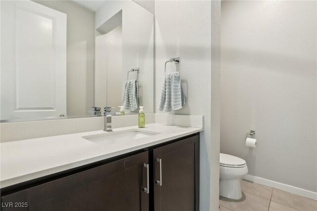 9690 Hiking Ave, Las Vegas, NV 89166 - bathroom featuring baseboards, toilet, vanity, and tile patterned floors