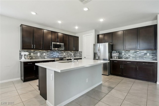 9690 Hiking Ave, Las Vegas, NV 89166 - kitchen with dark brown cabinetry, appliances with stainless steel finishes, a kitchen island with sink, light countertops, and a sink