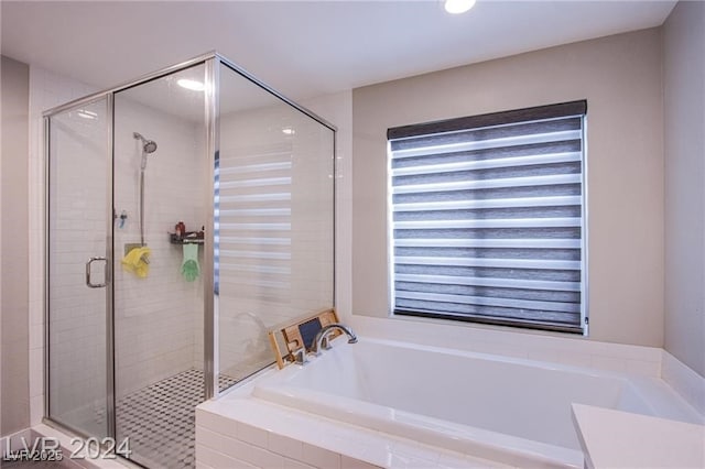 bathroom featuring shower with separate bathtub