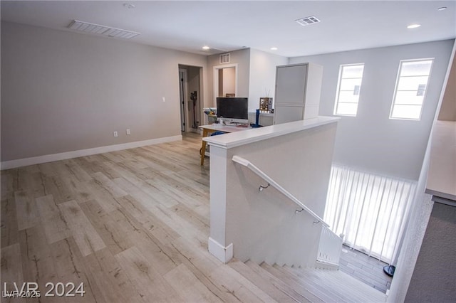 interior space with light wood-type flooring and kitchen peninsula